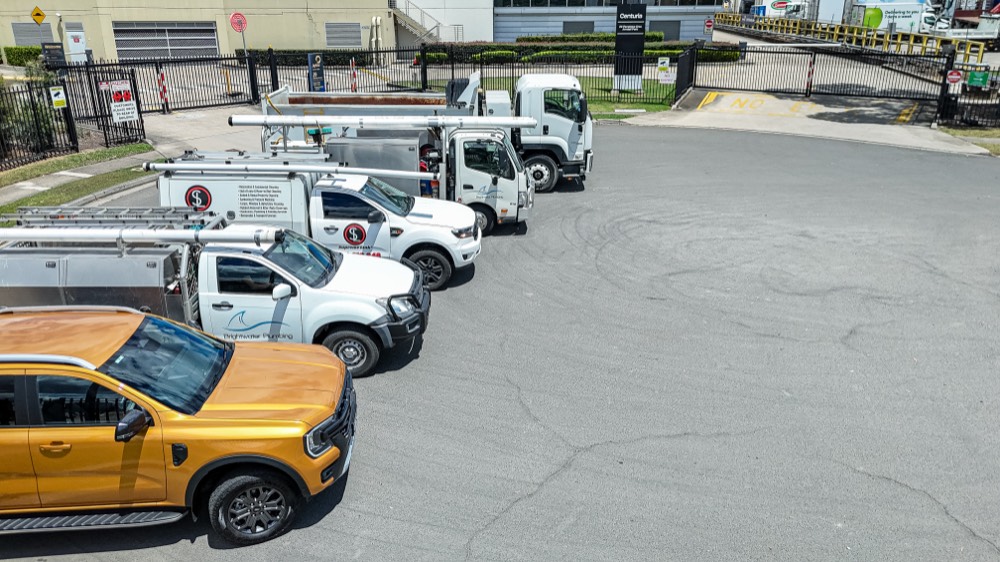 Aerial view of a managed fleet of utes lined up at a gated yard