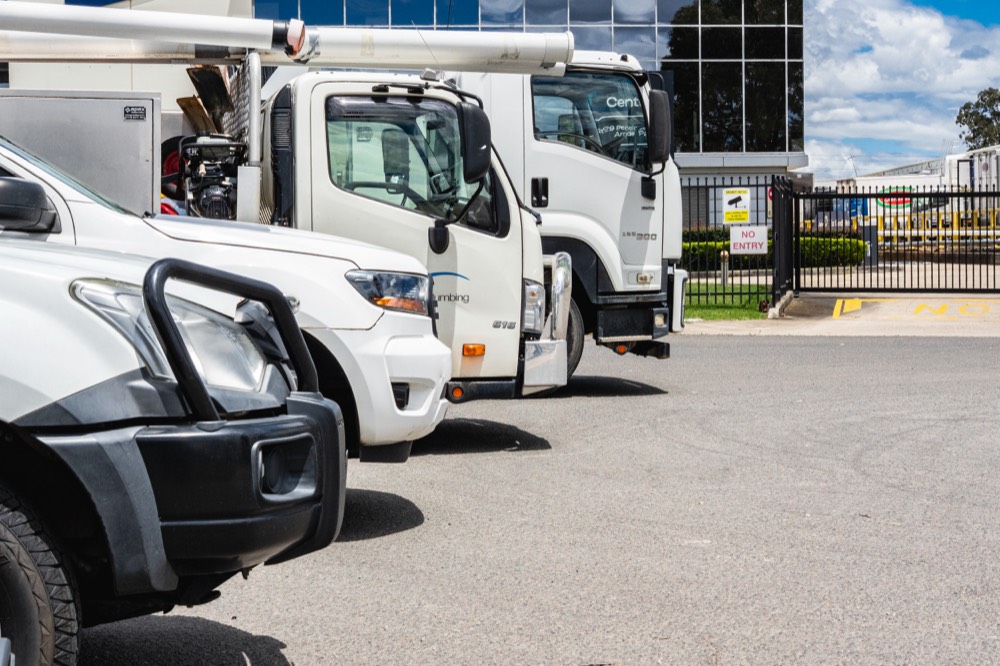 Front of a white work ute parked with the rest of the fleet